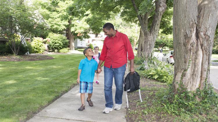 Adult and child walking to school safely.