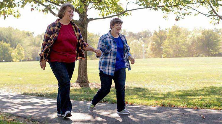 Mother walking with special needs child.